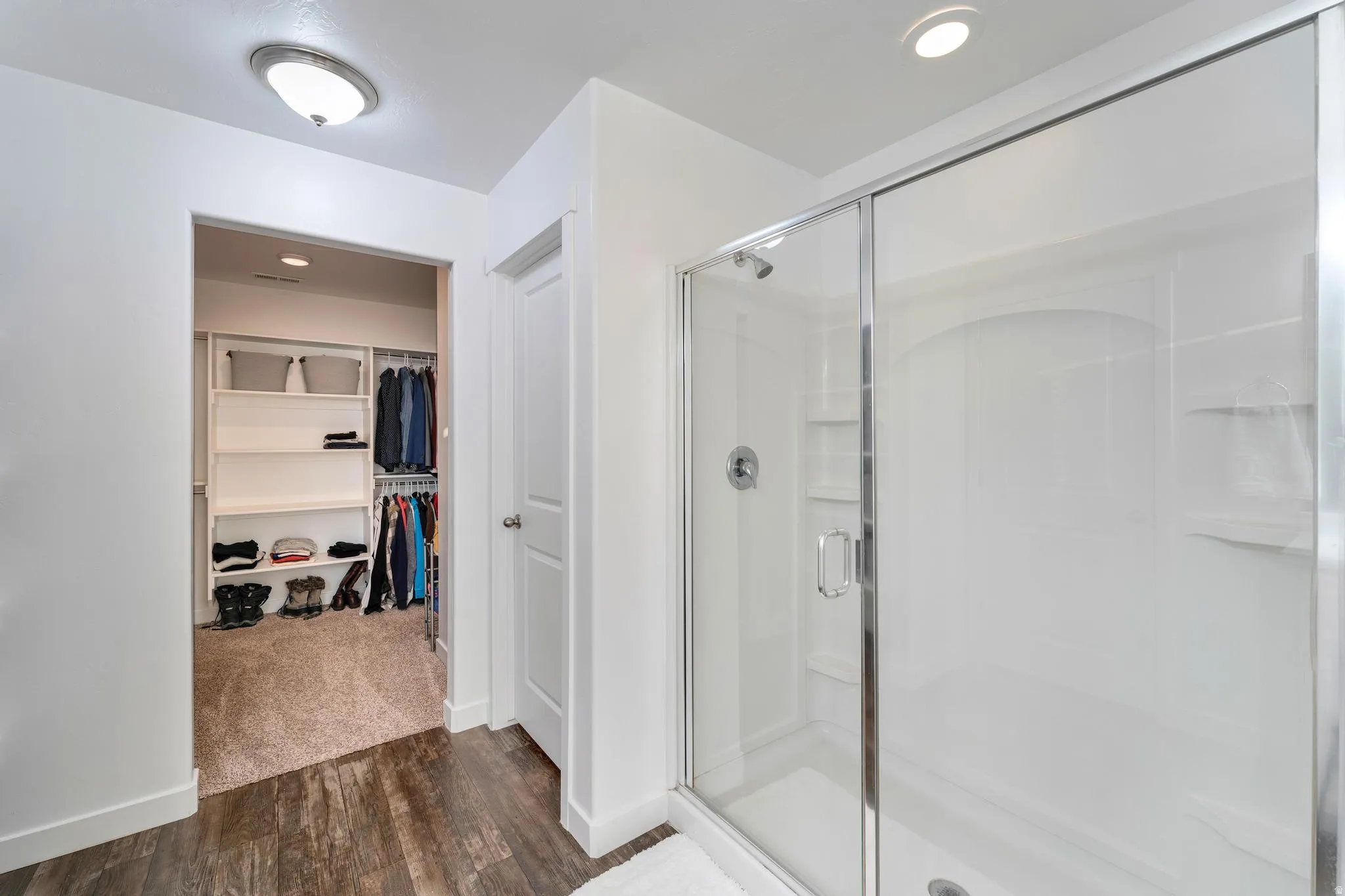 Modern shower enclosure with a sliding glass door and chrome fixtures