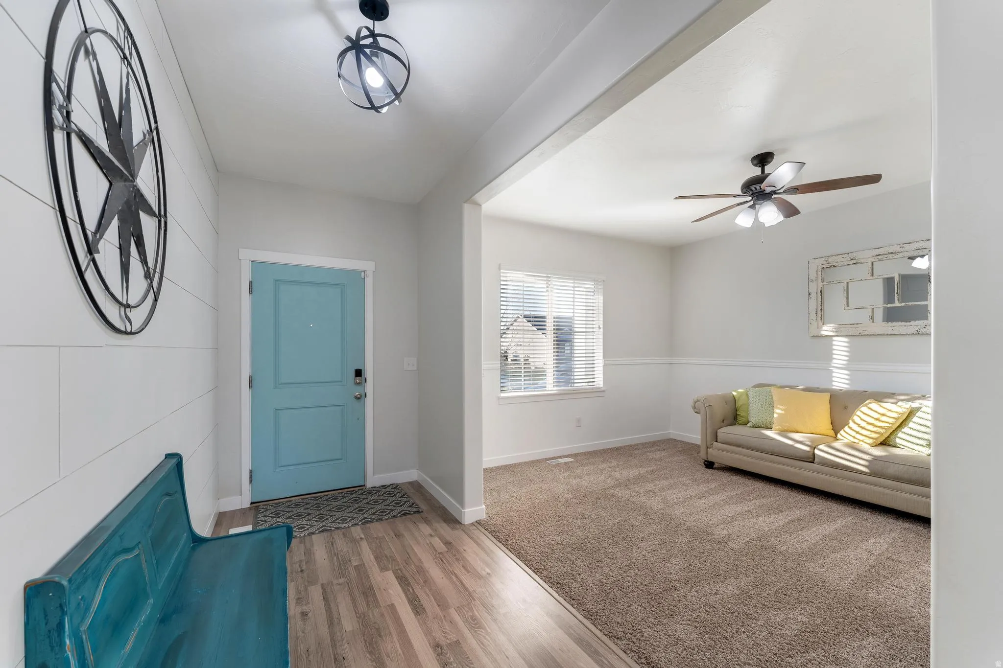 Inviting entryway featuring wood-finish flooring, a light blue entry door, and a modern globe-style light fixture