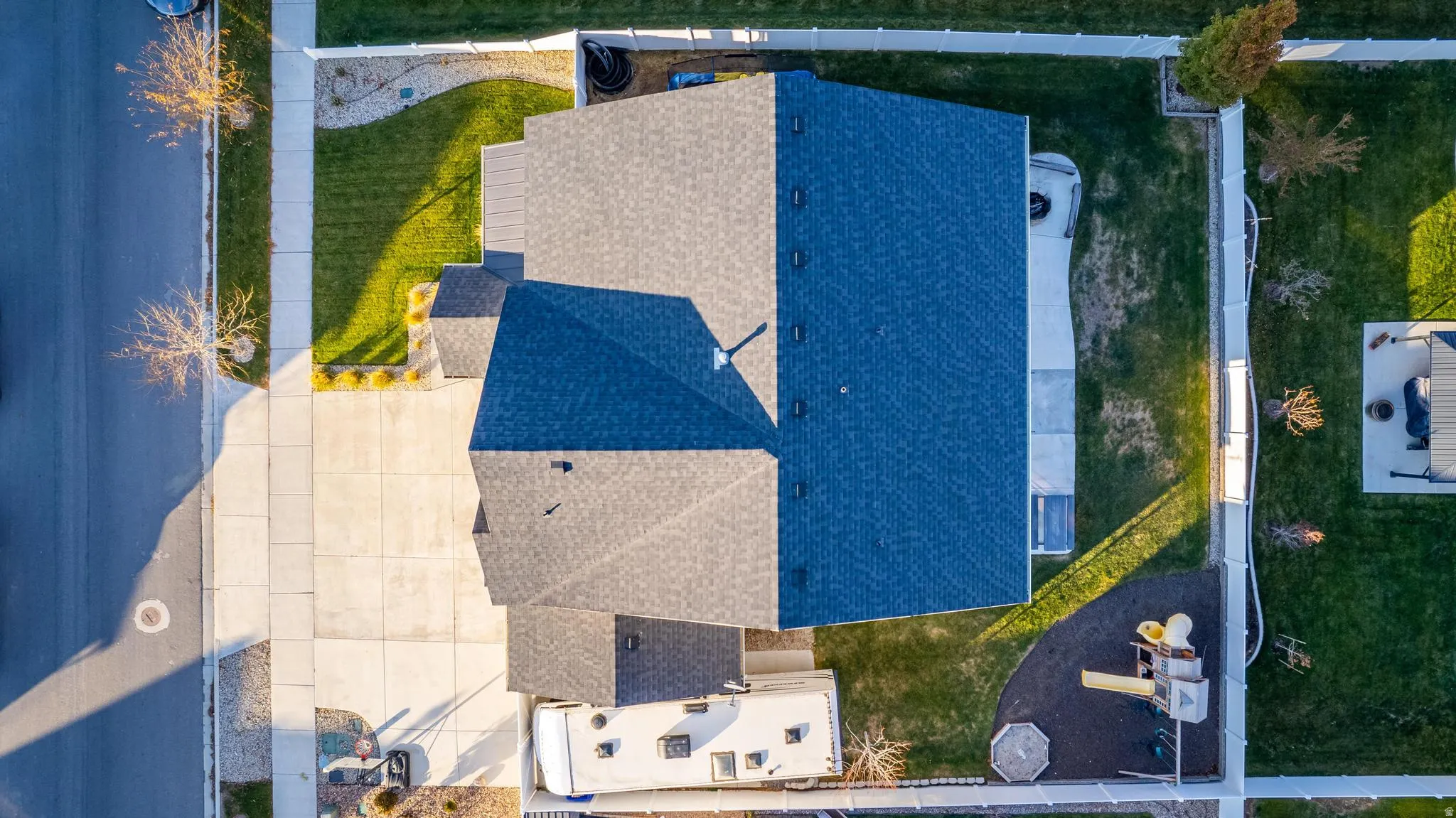 Aerial view showcasing the property's distinct dark gray and deep blue shingle roofing