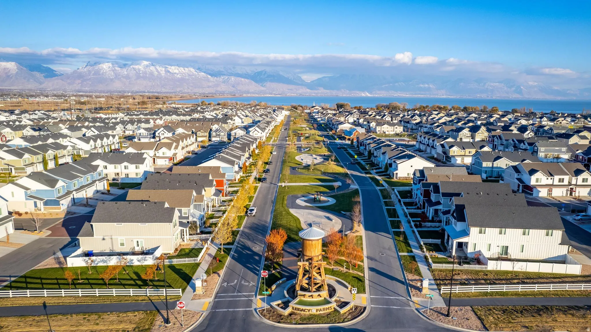 Expansive community featuring diverse residential architecture, a central parkway, and mountain backdrop