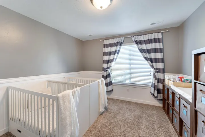 Room featuring a window with horizontal blinds, overhead flush mount lighting, and neutral wall paint