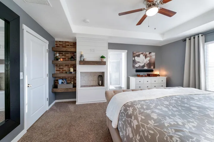 Bedroom featuring tray ceiling, ceiling fan, and carpeted flooring