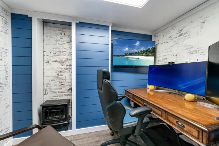 Dedicated workspace featuring blue shiplap paneling and distressed brick accent walls