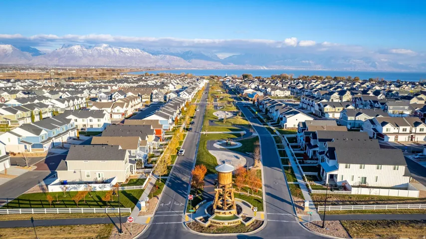 Expansive community featuring diverse residential architecture, a central parkway, and mountain backdrop