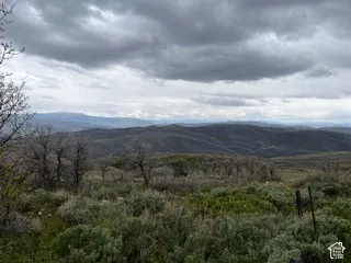 Expansive landscape featuring rolling hills and distant mountains