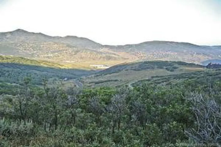 Expansive mountain landscape featuring varied terrain and distant structures