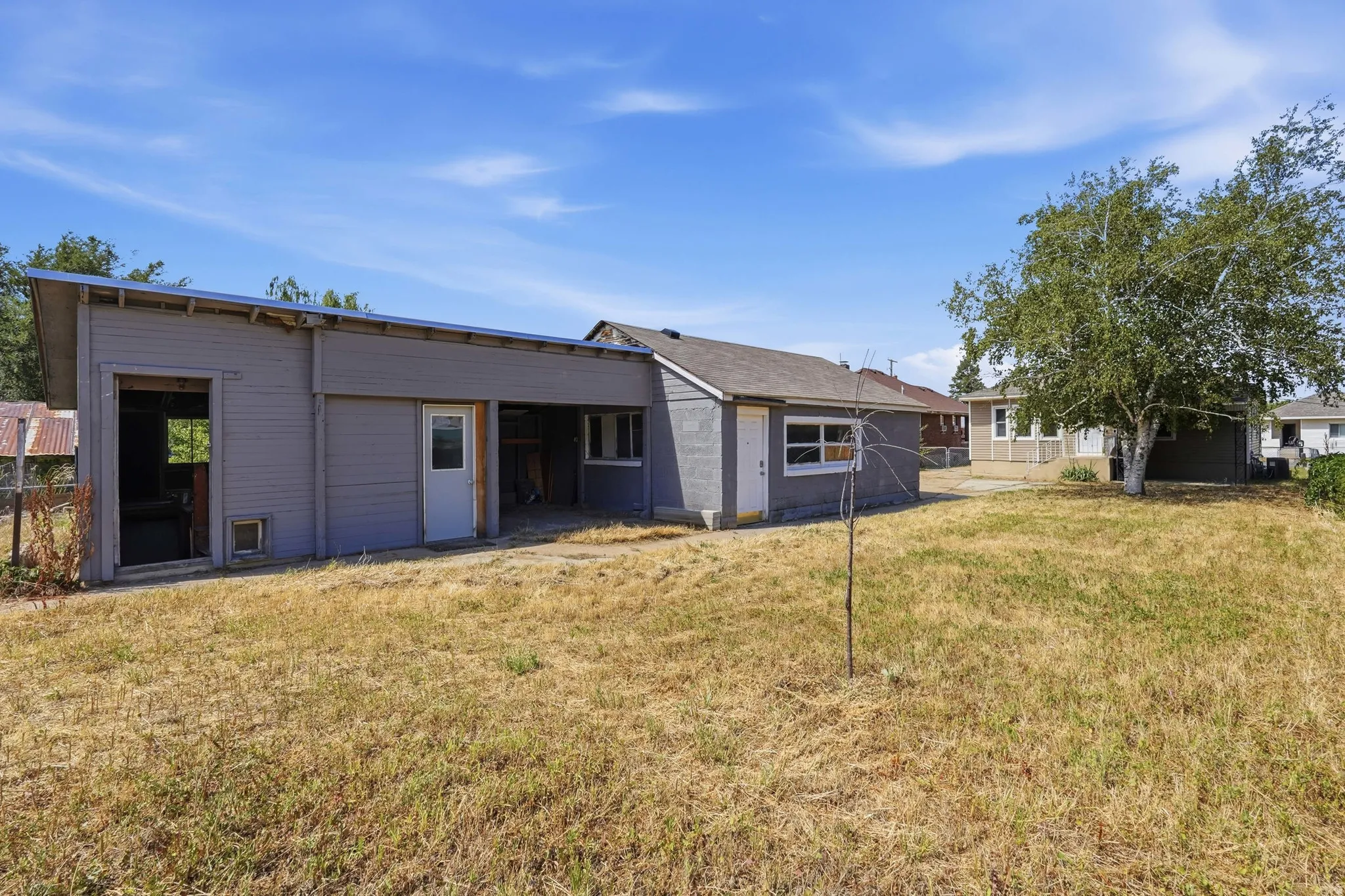 Expansive rear yard with a mature tree, offering ample outdoor space