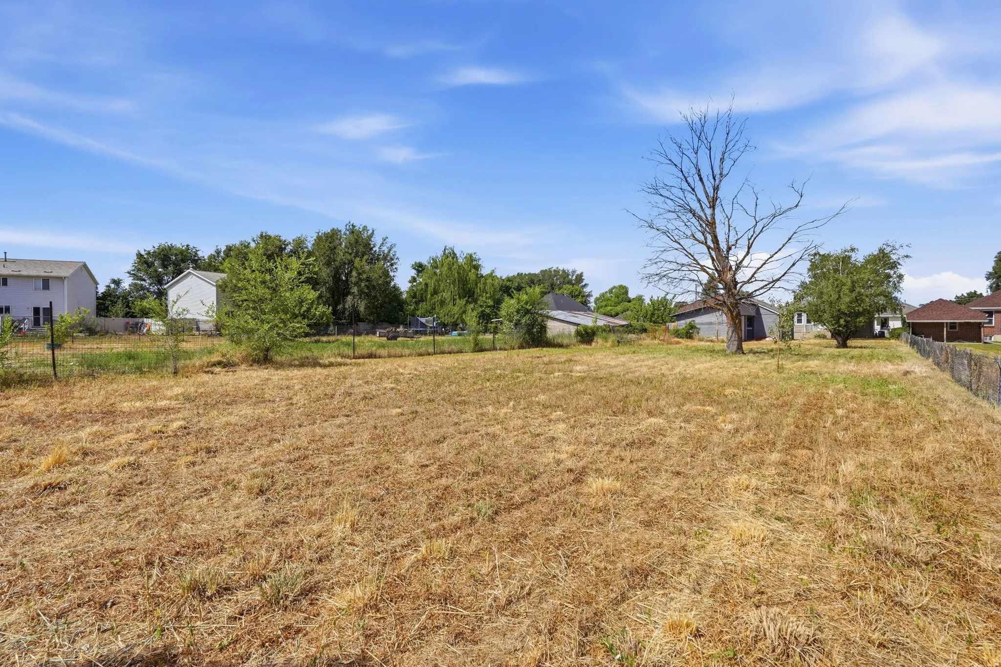 Expansive open lot featuring a dry grass ground cover