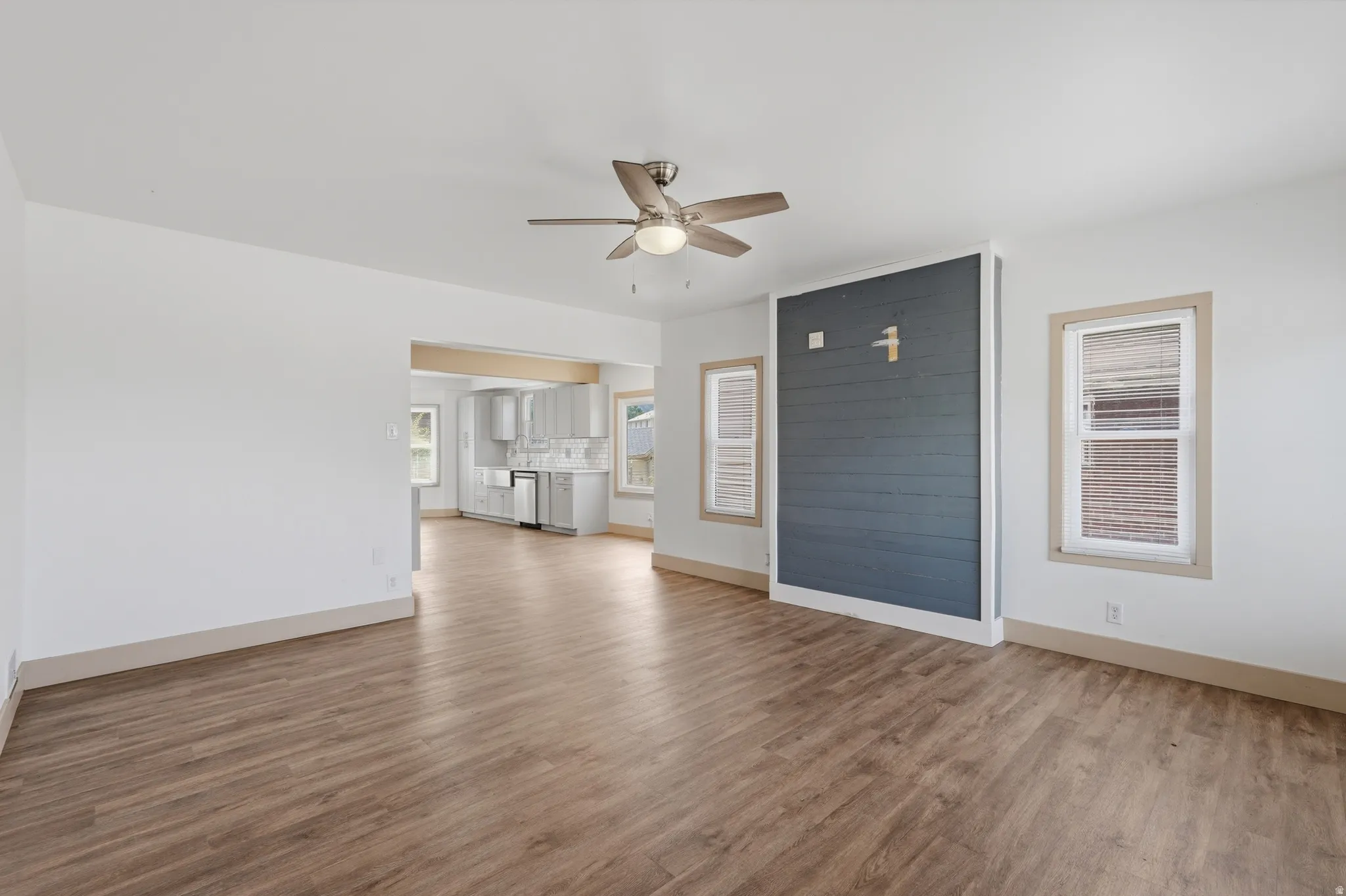 Open concept living space featuring wood-finish flooring and a contemporary ceiling fan