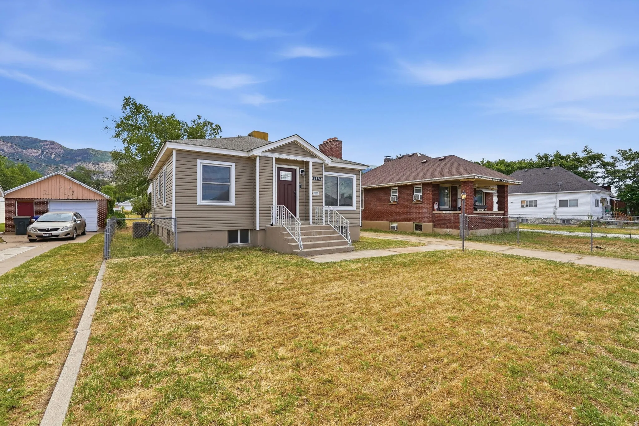 Residential property featuring a light brown siding exterior and a dark brown front door