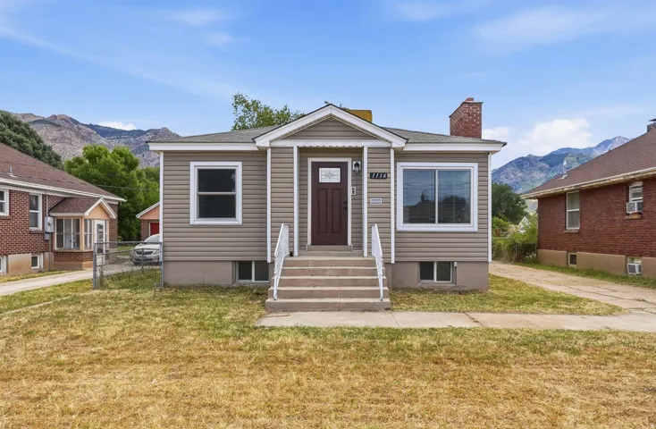 Exterior featuring light beige siding, a dark brown entry door, and white trim