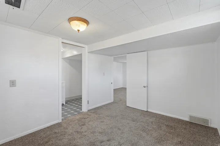 Interior room featuring neutral-toned carpeting and white painted walls
