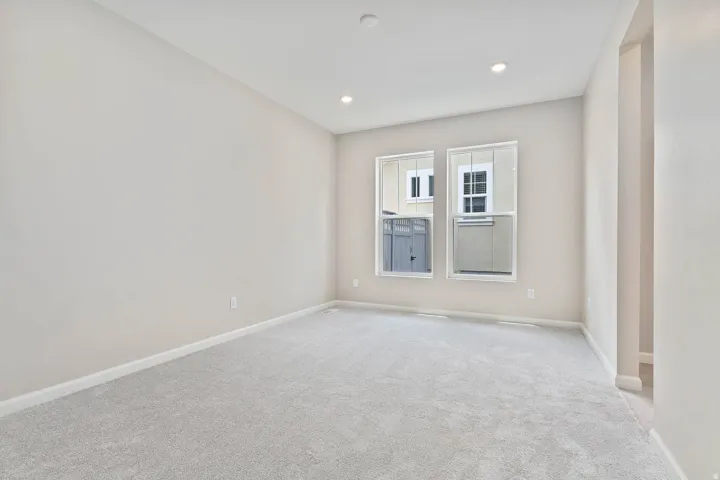 Spacious room with plush gray carpeting, neutral wall finishes, and recessed ceiling lighting