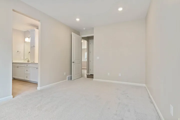 Carpeted room with recessed lighting and a full-light door
