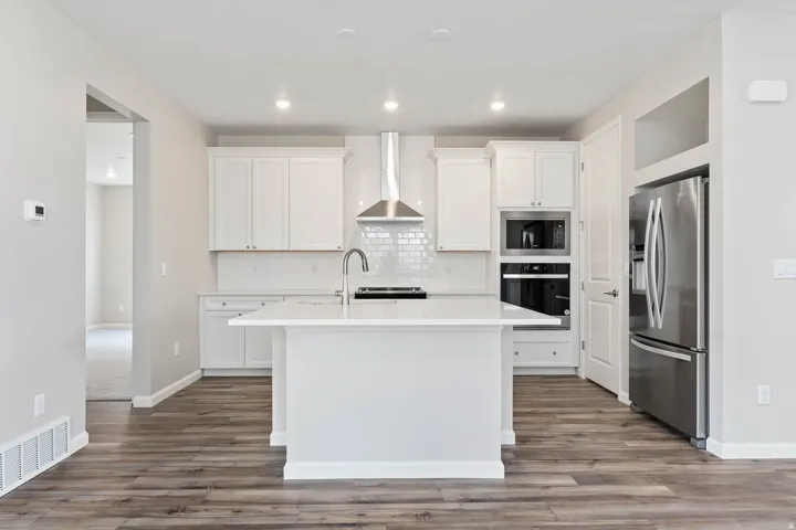 Modern kitchen with white cabinetry and wood-finish flooring