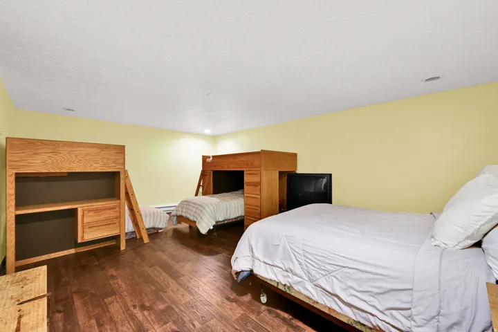 Bedroom featuring wood-finish flooring, recessed lighting, and light yellow wall paint