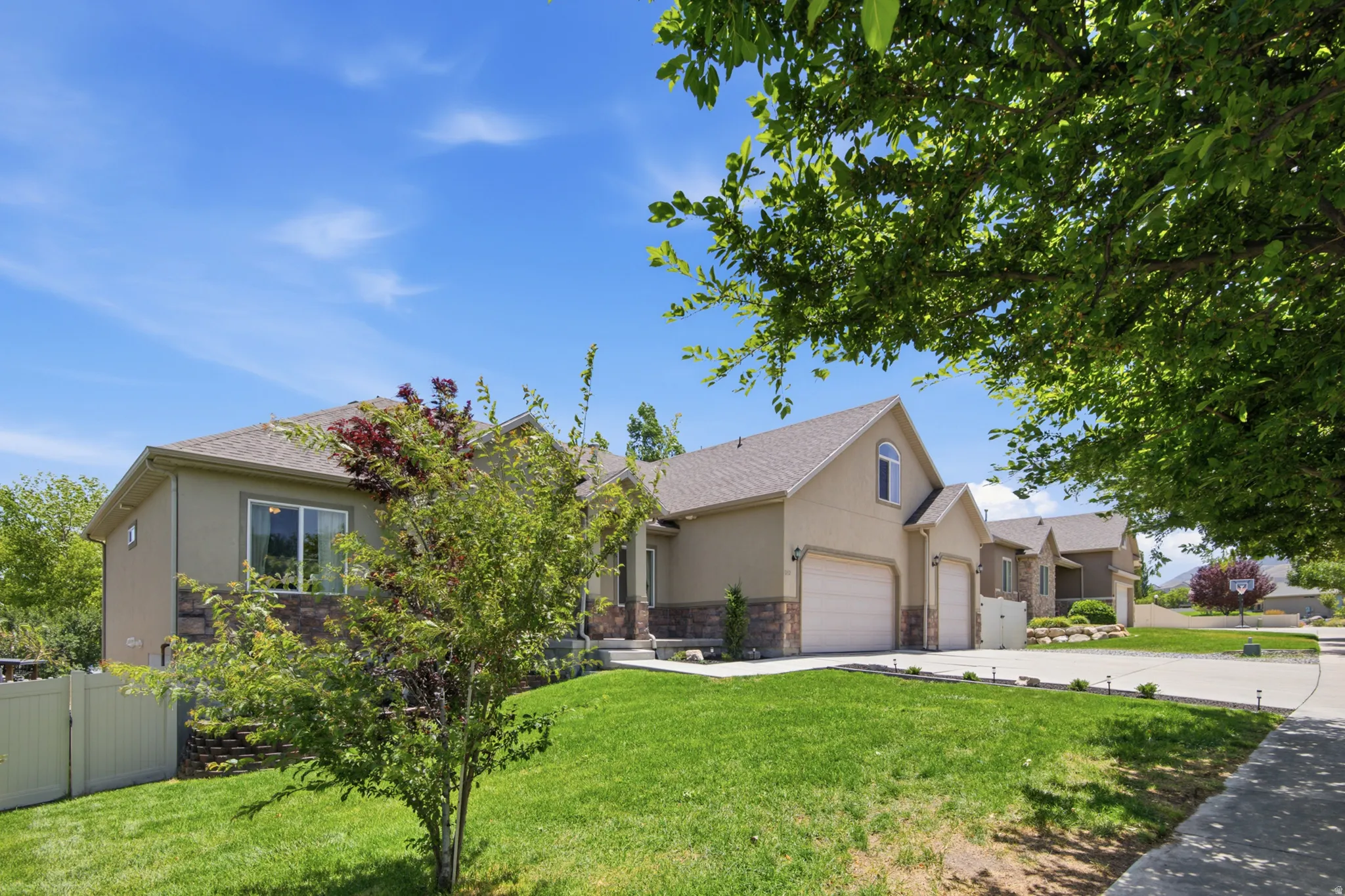 Contemporary stucco exterior with stone accents and a two-car garage