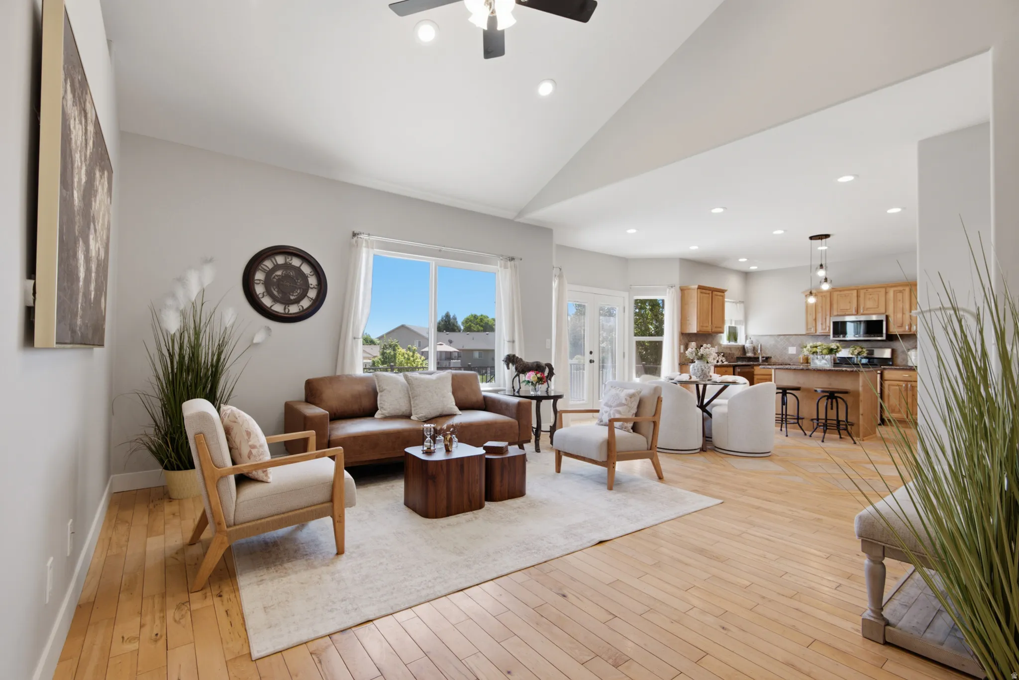 Vaulted ceiling living area featuring light wood-finish flooring and recessed lighting