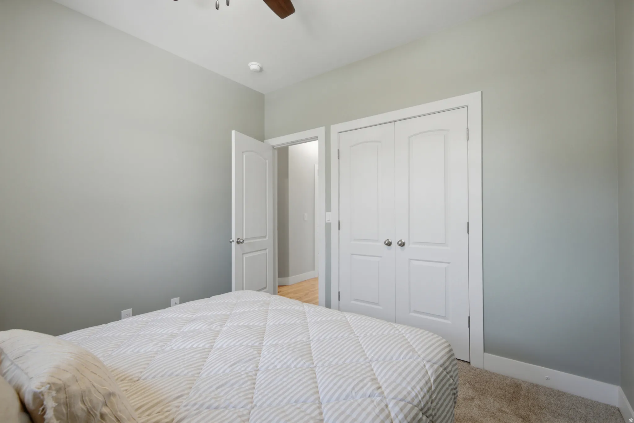 Bedroom featuring light gray walls, white trim, and a ceiling fan