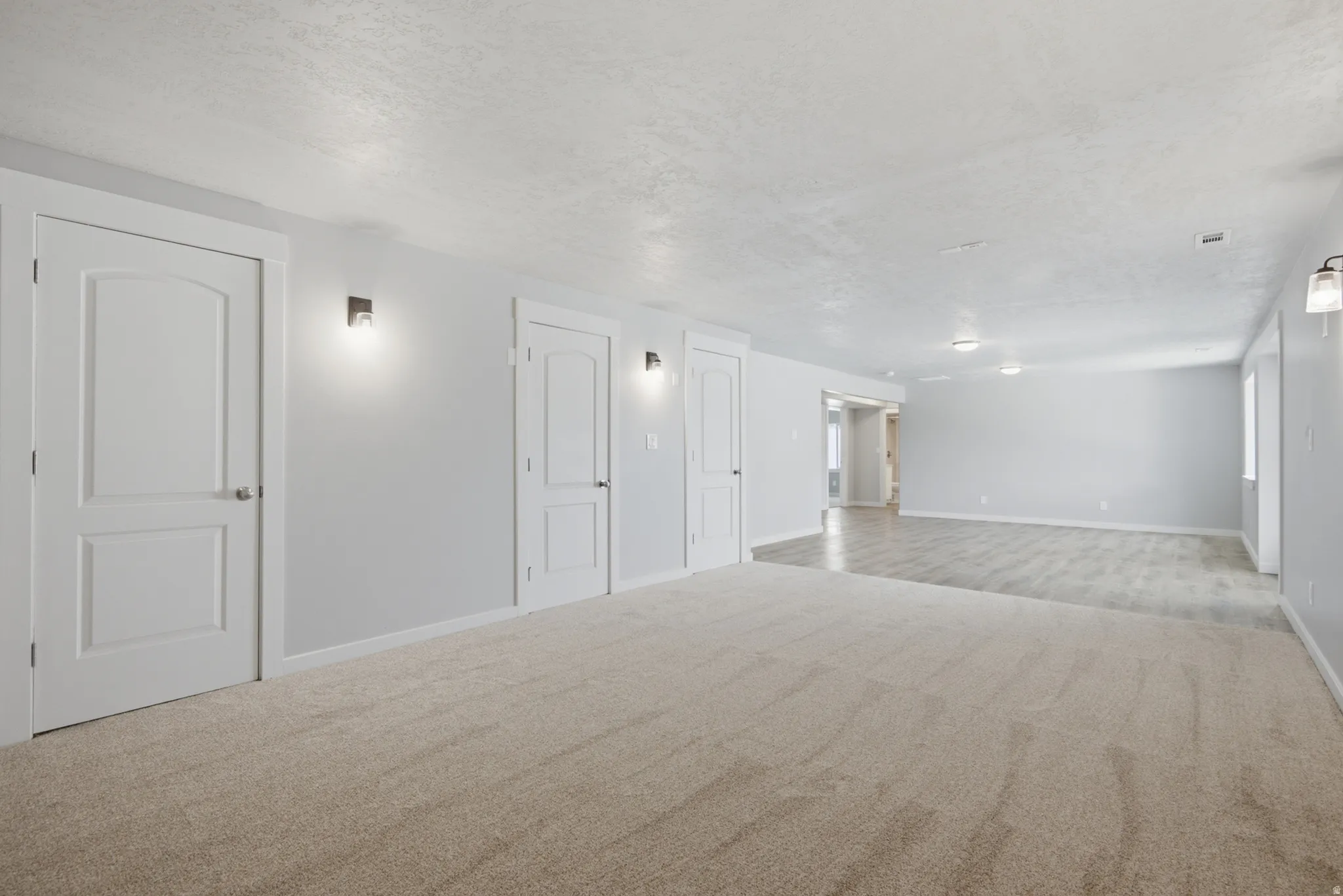 Spacious room featuring neutral carpeting and light gray walls