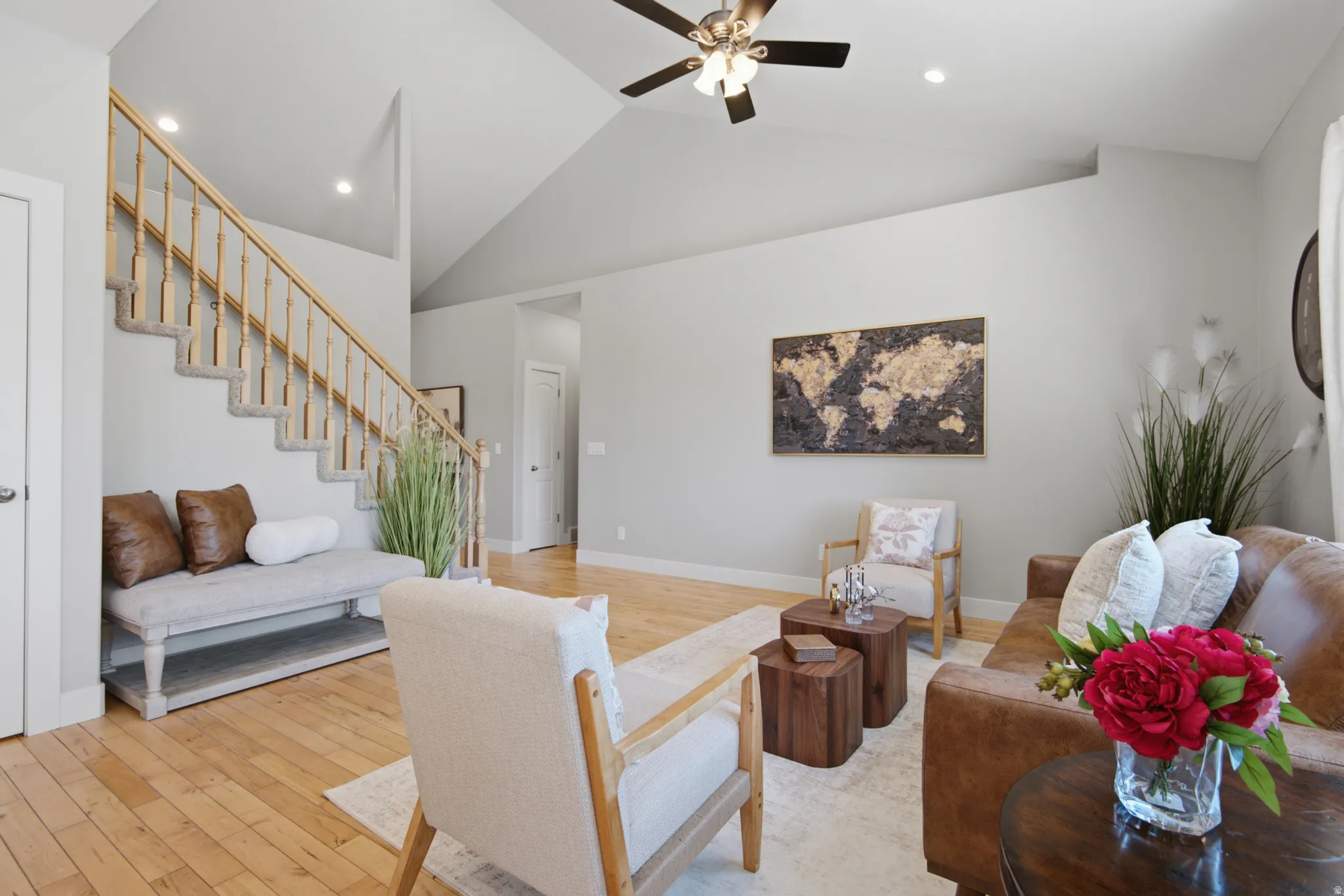 Vaulted ceilings with a ceiling fan and recessed lighting define this spacious living area