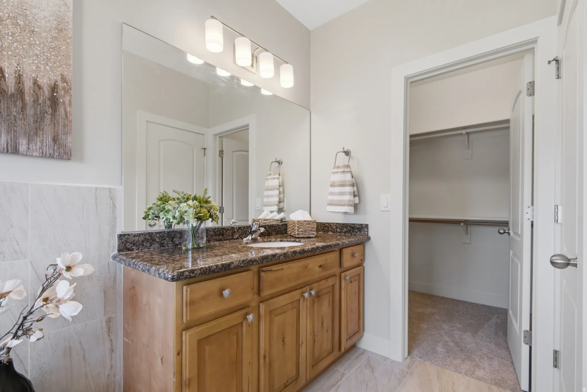 Vanity with a granite countertop, undermount sink, and wood-finish cabinetry