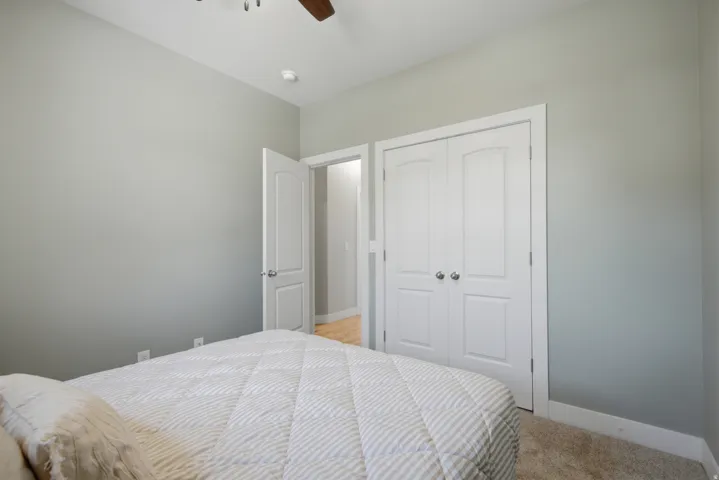 Bedroom featuring light gray walls, white trim, and a ceiling fan