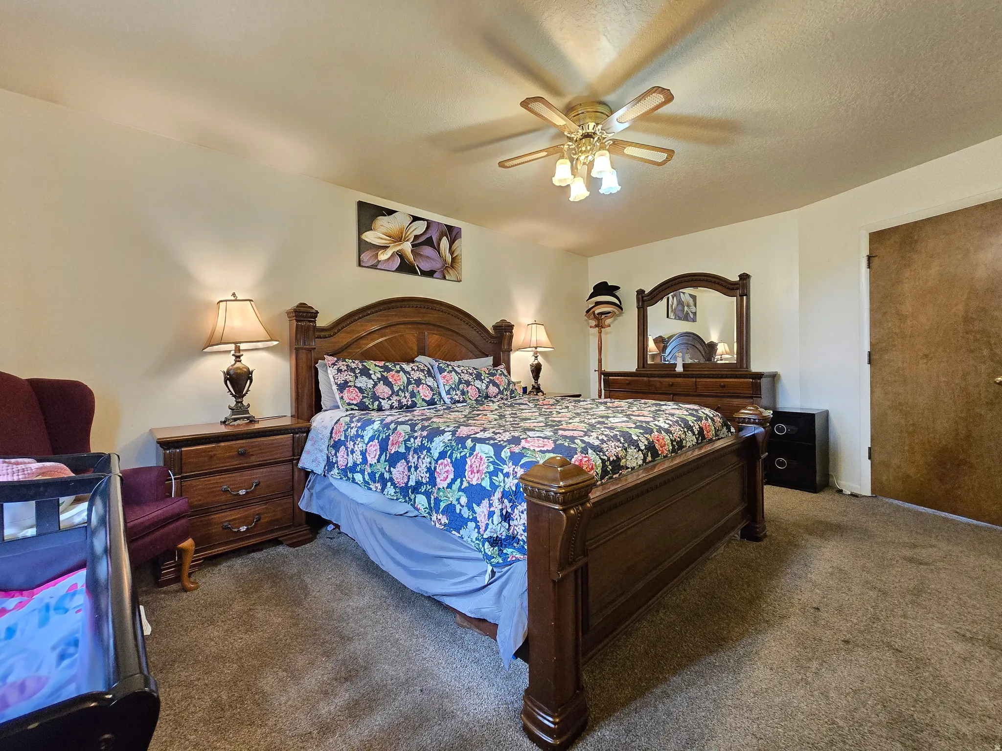 Bedroom featuring carpet flooring, a ceiling fan with integrated lighting, and a wood-finish interior door