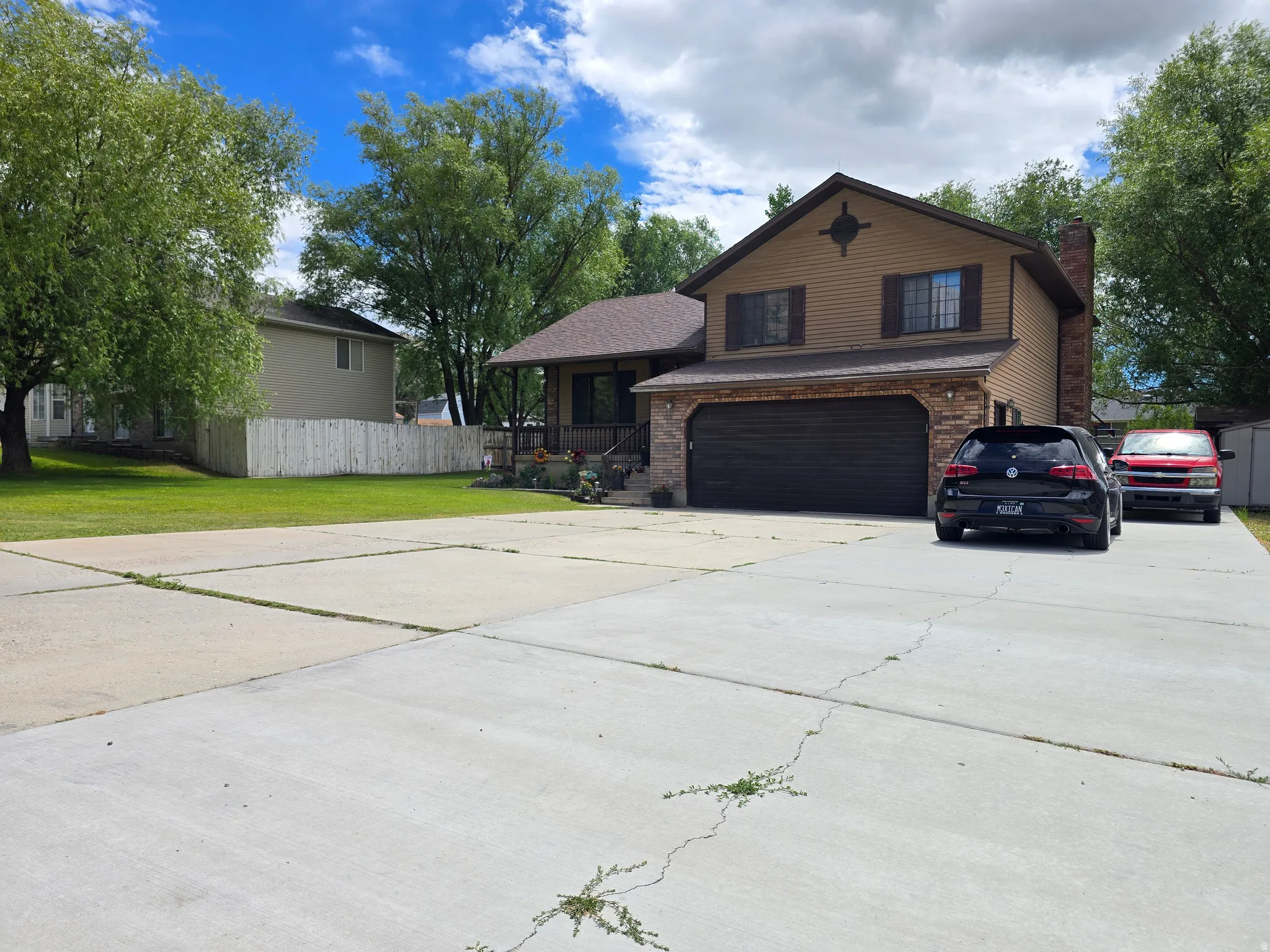 Two-story residence featuring a brown siding exterior, brick accents, and a dark brown garage door