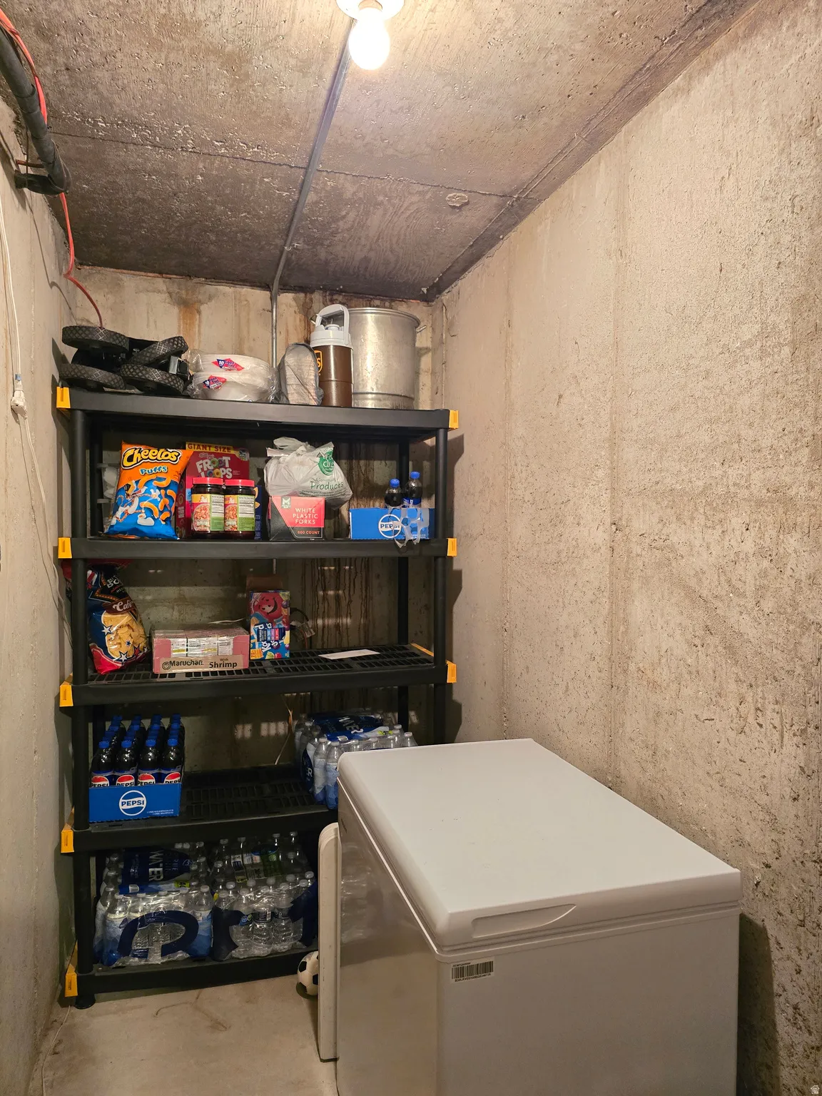 Utility space featuring bare concrete walls and ceiling