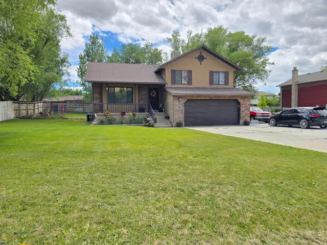 Two-story exterior with a stone facade, attached garage, and concrete driveway