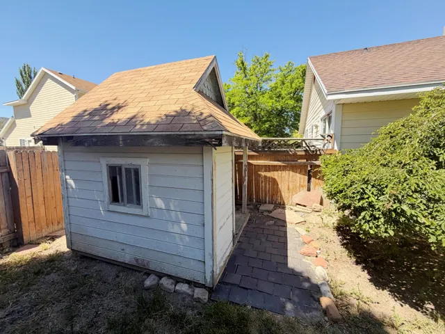 Detached storage shed featuring a gabled roof with asphalt shingles and horizontal siding
