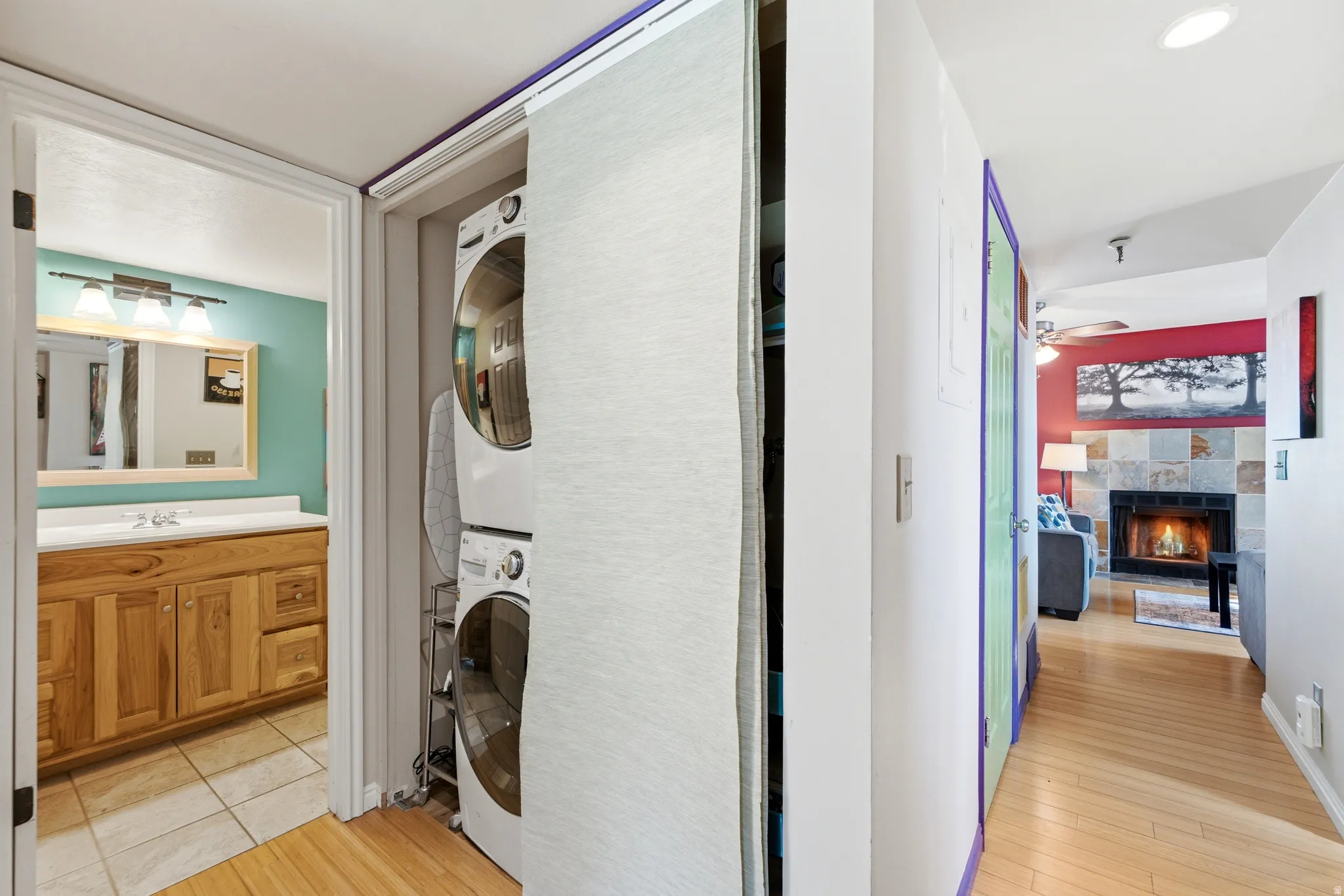 Hallway featuring wood-finish flooring, recessed lighting, and a stacked washer and dryer behind a sliding door