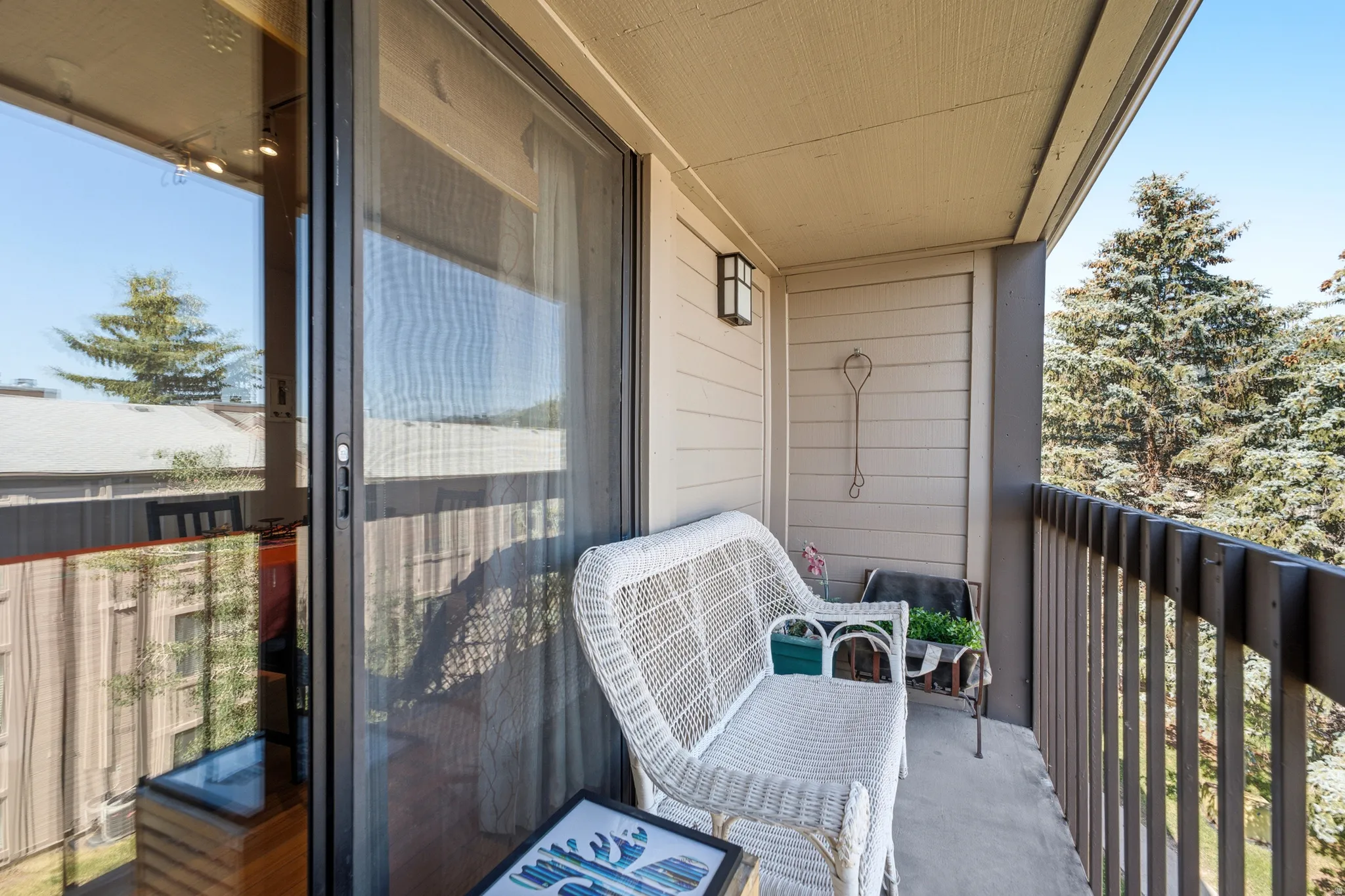 Private balcony featuring a concrete floor, horizontal siding, and an exterior wall lantern