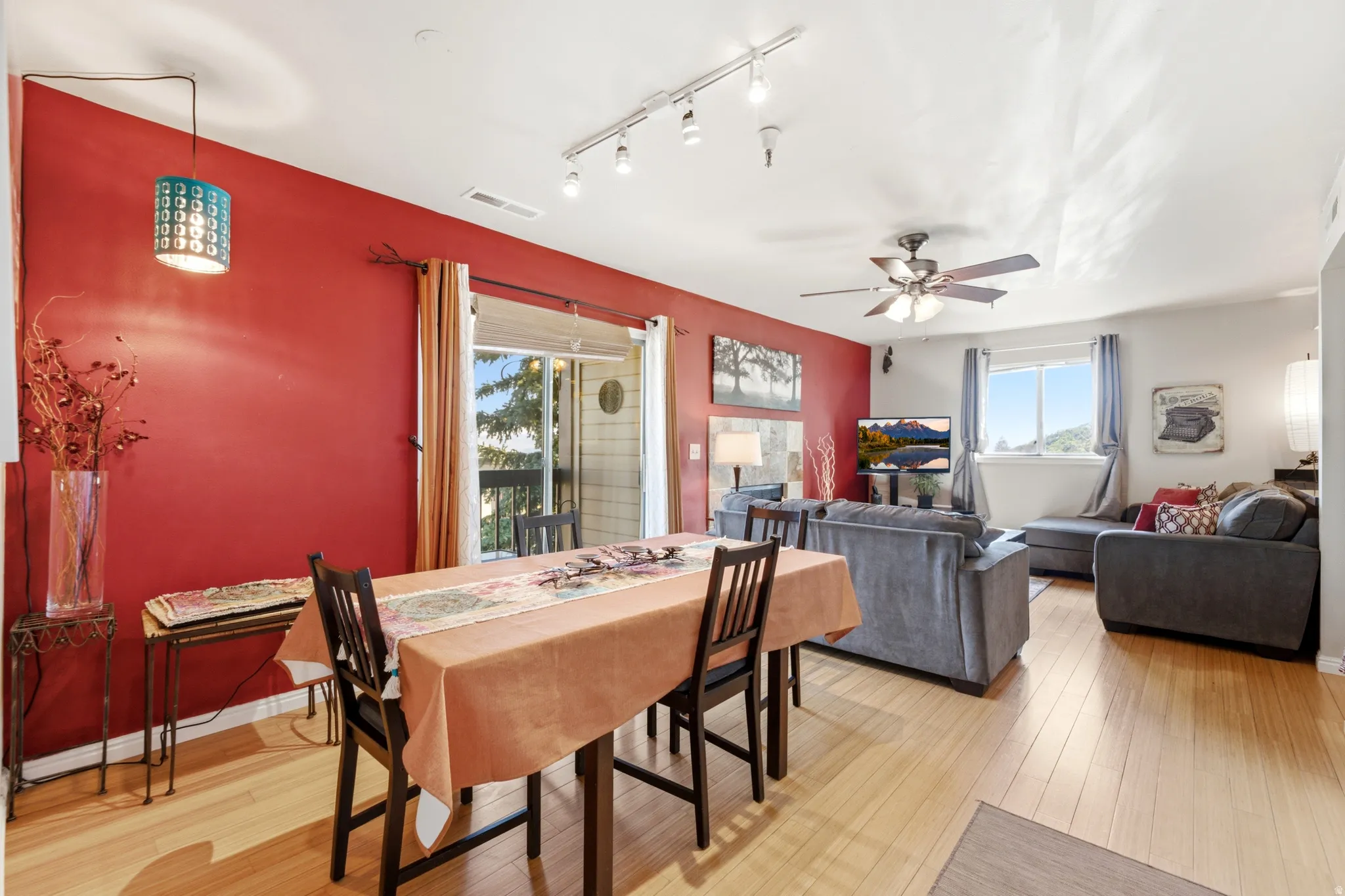 Spacious interior with light wood-finish flooring, a ceiling fan, and track lighting