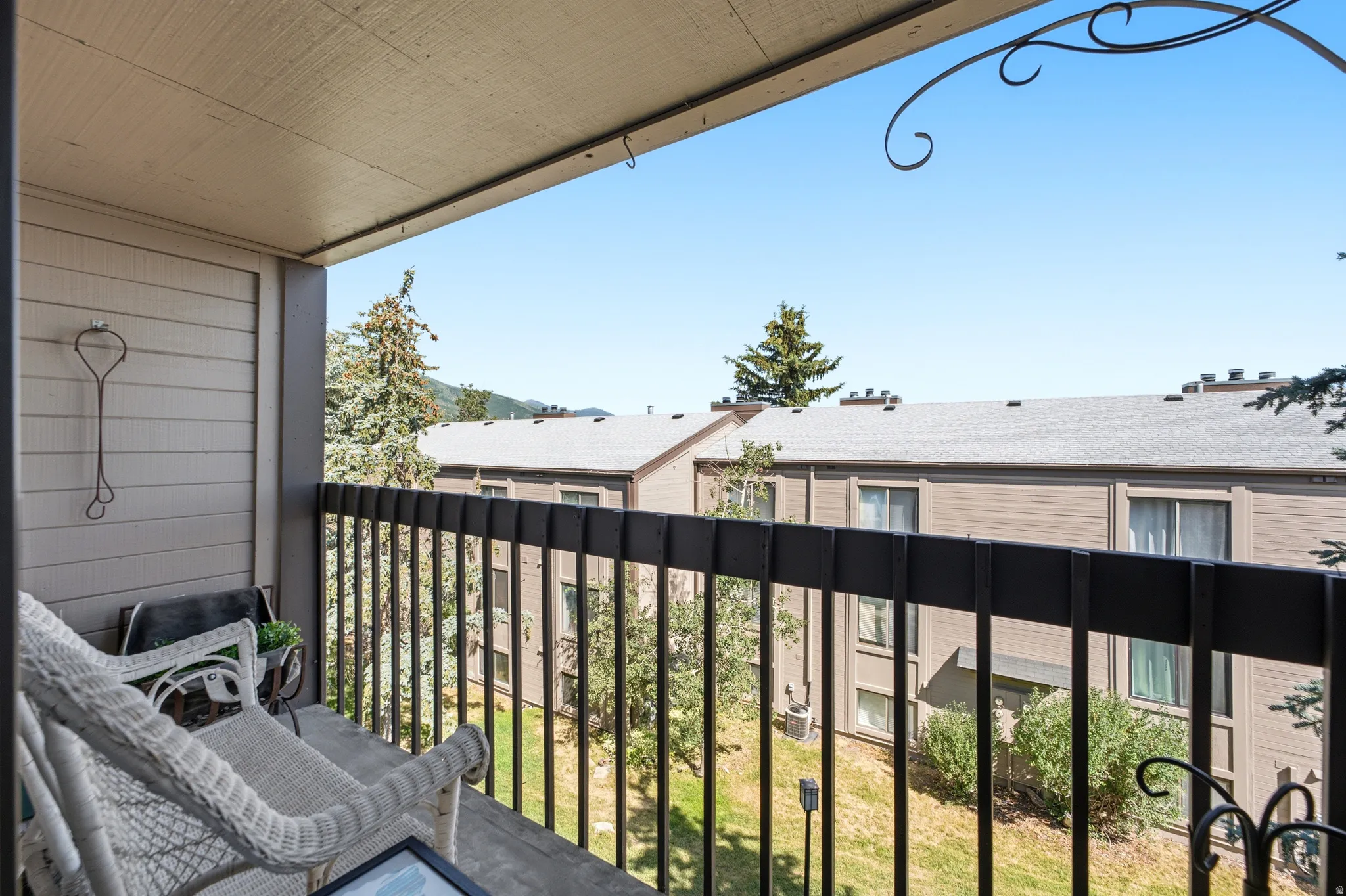 Private balcony featuring horizontal siding, a metal railing, and an overhead lighting fixture