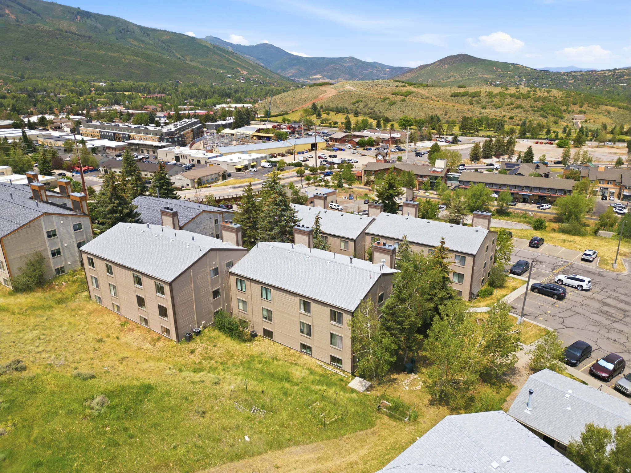 Multi-story buildings with pitched gray roofs, tan siding, and multiple windows