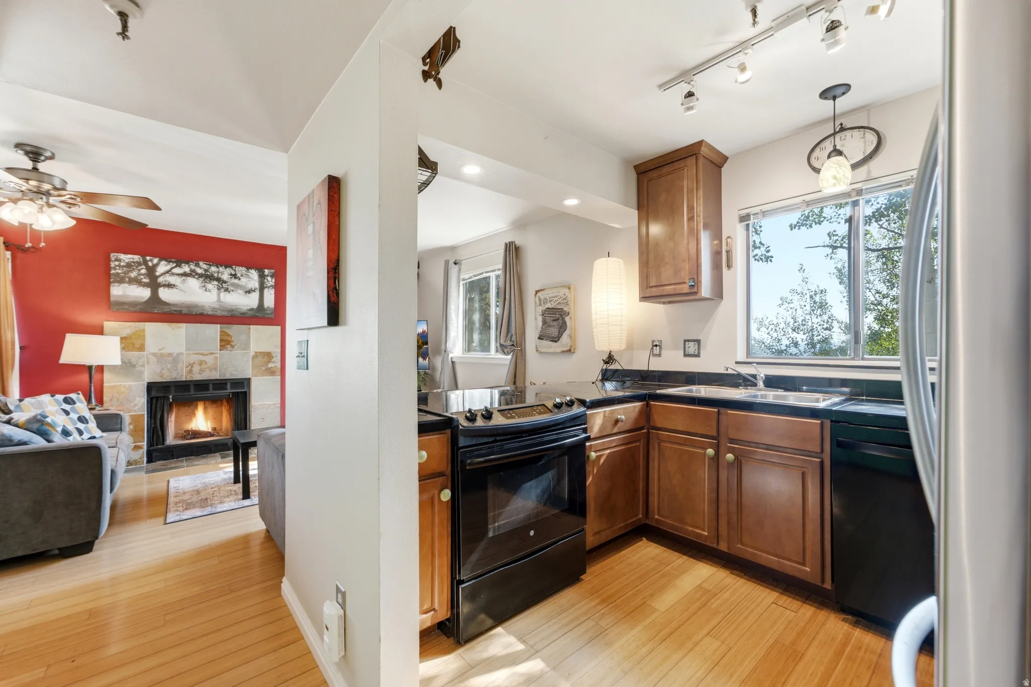 Functional kitchen featuring wood cabinetry, dark countertops, and black appliances