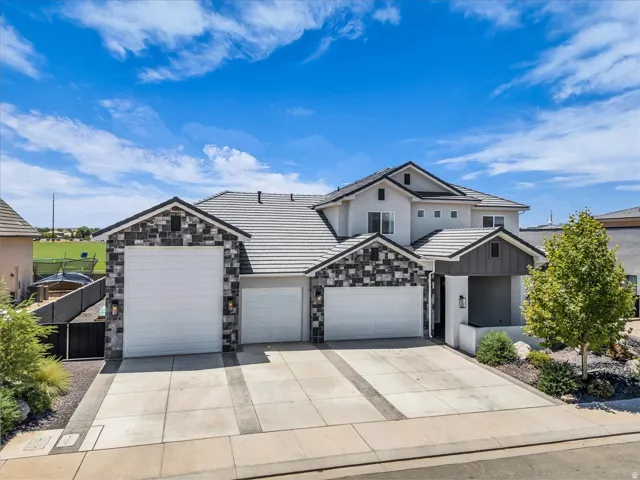 Contemporary two-story residence featuring a combination of light-colored stucco and multi-tone stone veneer