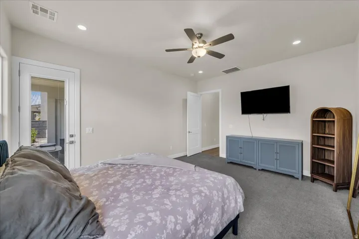 Spacious room featuring neutral-toned walls, recessed lighting, and a ceiling fan with integrated light