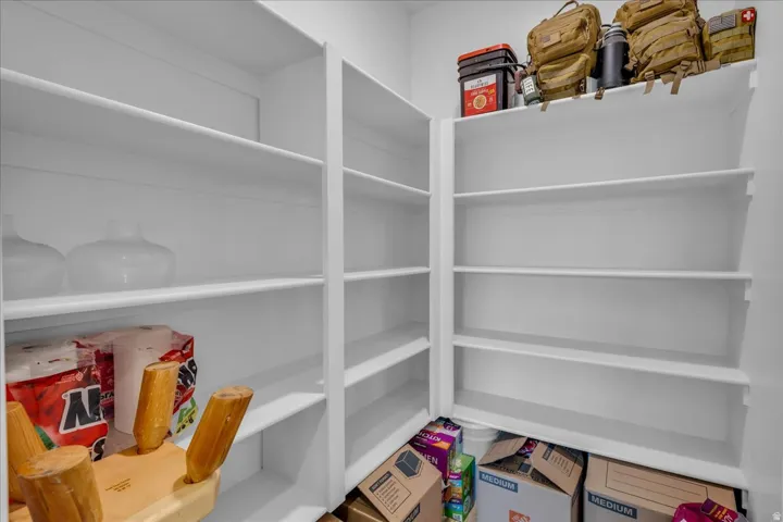 Walk-in pantry with extensive white shelving for organized storage