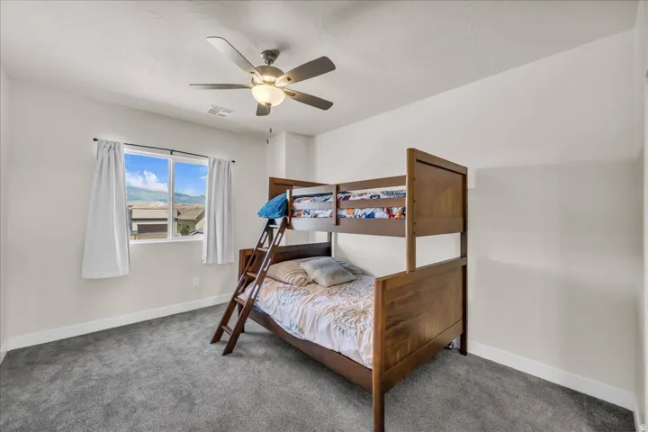 Bedroom with gray carpeting and light-colored walls