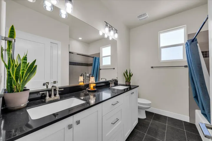 Double vanity with integrated sinks and dark countertops