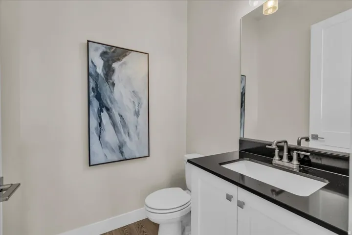 Bathroom featuring a white vanity with silver hardware, a black countertop, and an undermount sink