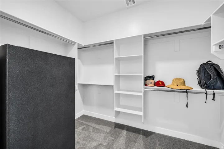 Walk-in closet with integrated shelving units and hanging rods