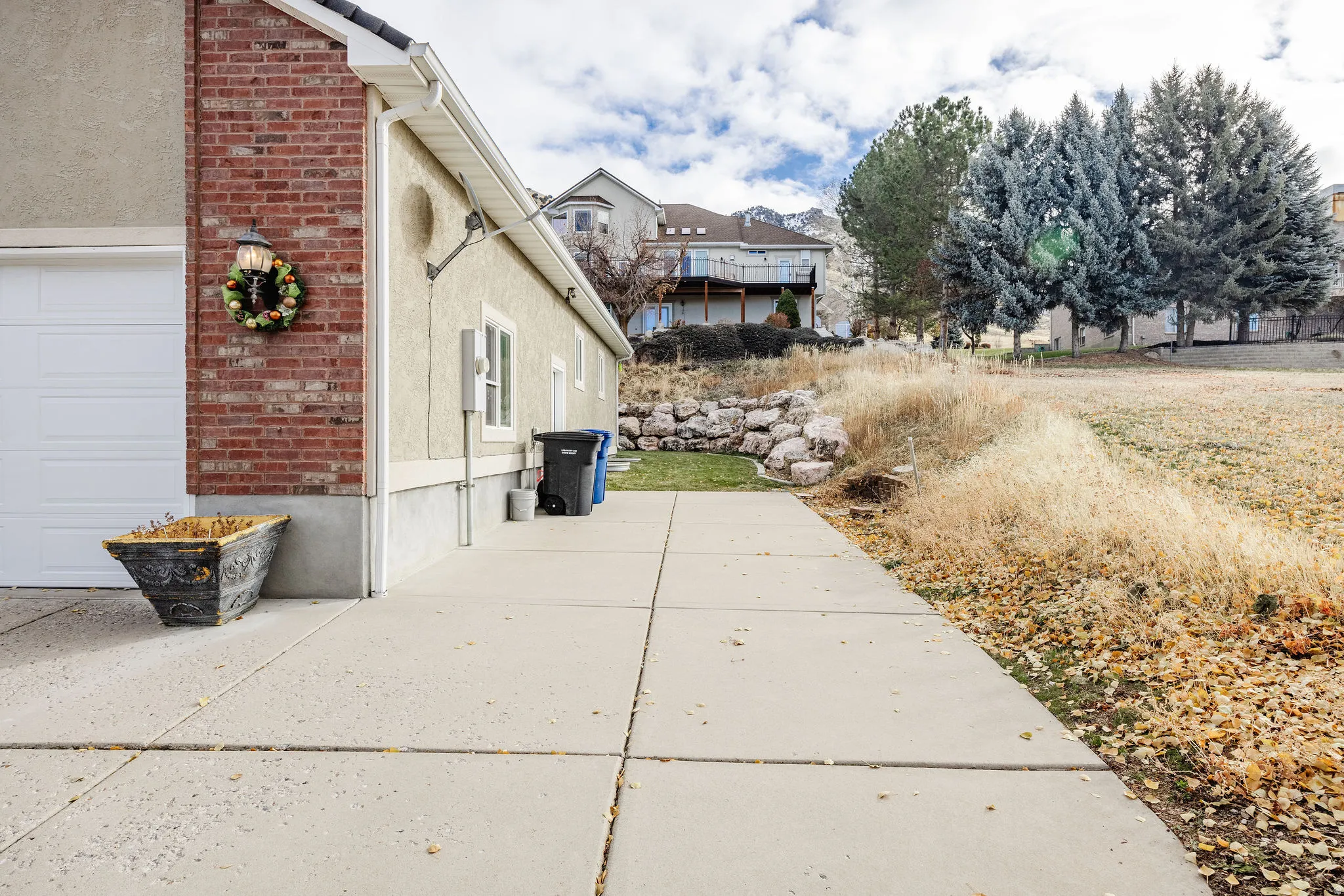 Concrete driveway leading to an attached garage with a white sectional door
