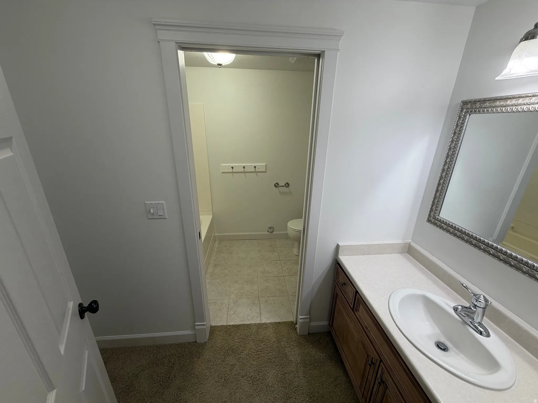Bathroom vanity with an integrated sink, polished chrome faucet, and decorative framed mirror