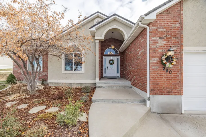 Entryway featuring an arched portico, a white front door with an arched transom, and a concrete pathway