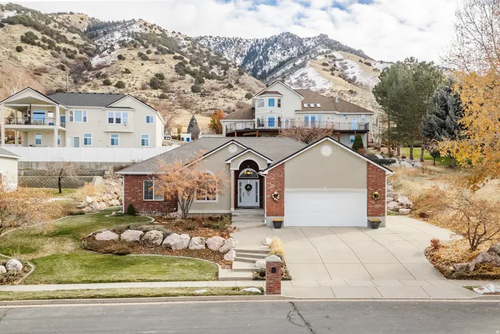 Ranch-style exterior featuring a two-car garage, brick and stucco facade, and a concrete driveway