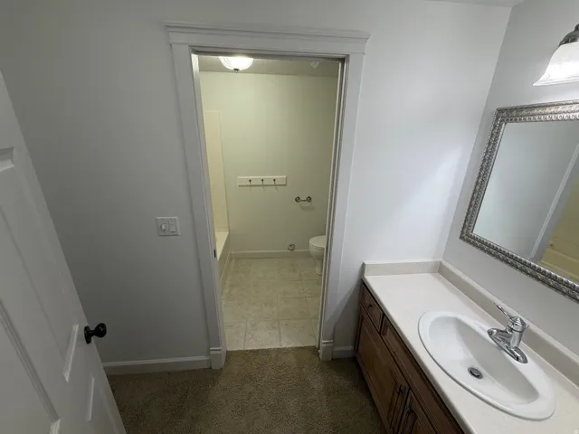 Bathroom vanity with an integrated sink, polished chrome faucet, and decorative framed mirror
